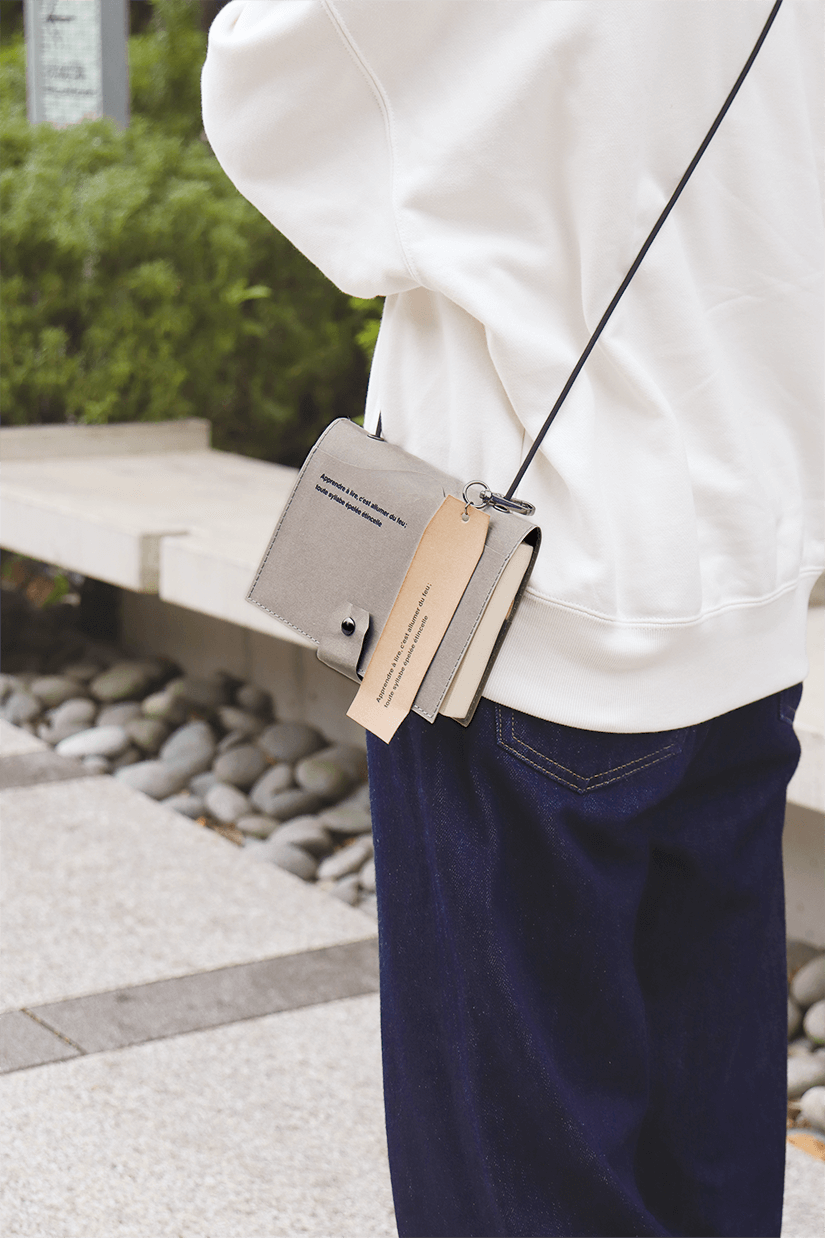 ウォッシャブルペーパーブックカバー　グレー　肩から下げている写真